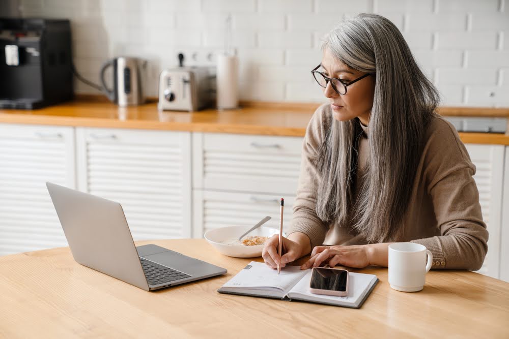 Businesswoman planning tech updates while having breakfast